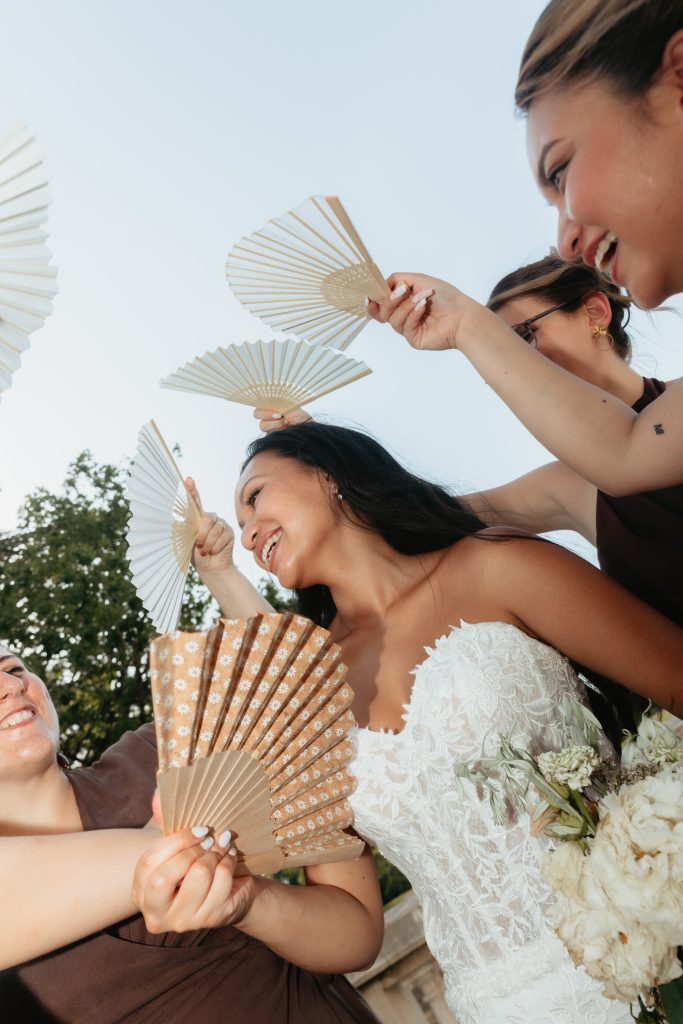 Les demoiselles d’honneur rafraichissent la mariée à l’aide de leurs éventails