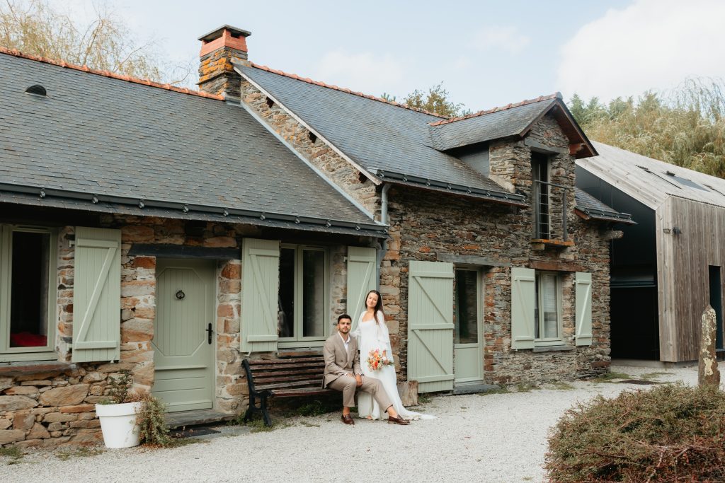 Photo de couple des mariés devant le lieu de réception