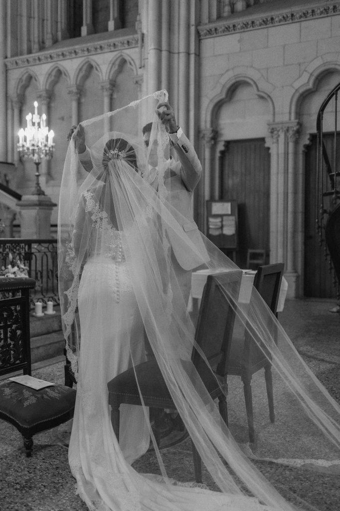 Le marié retire le voile de la mariée lors de la cérémonie religieuse à l’église