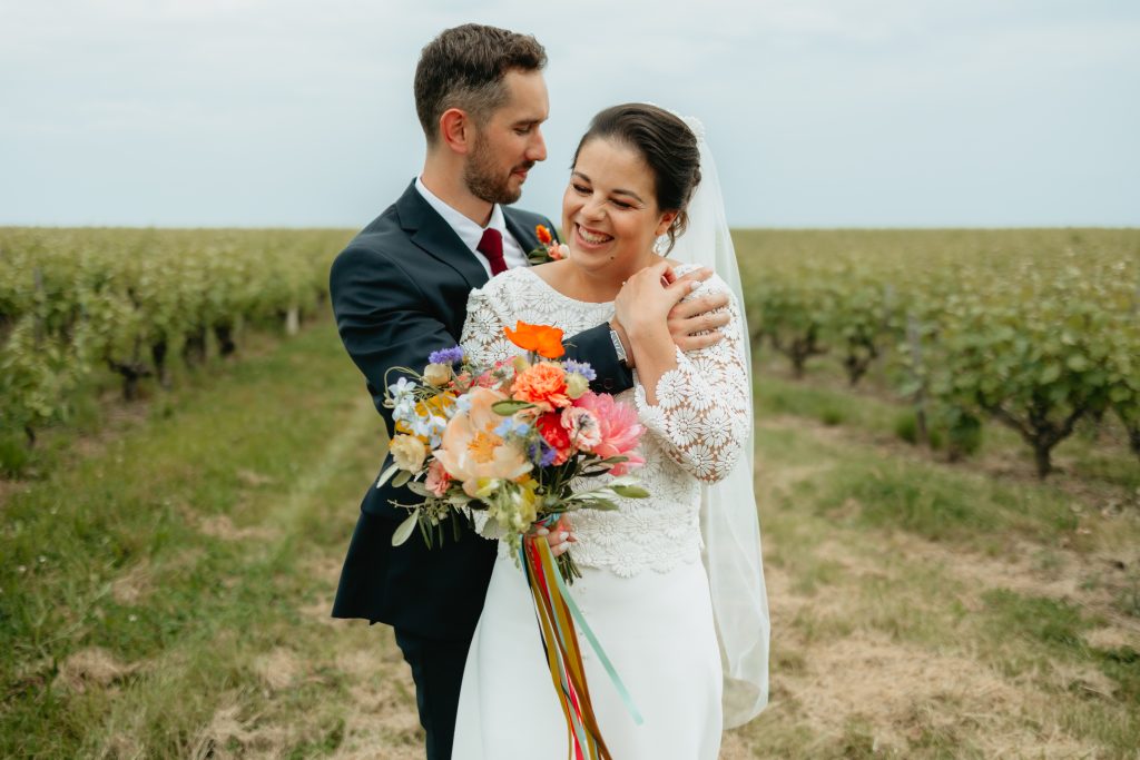 Les mariés en séance couple dans les vignes qui rigolent
